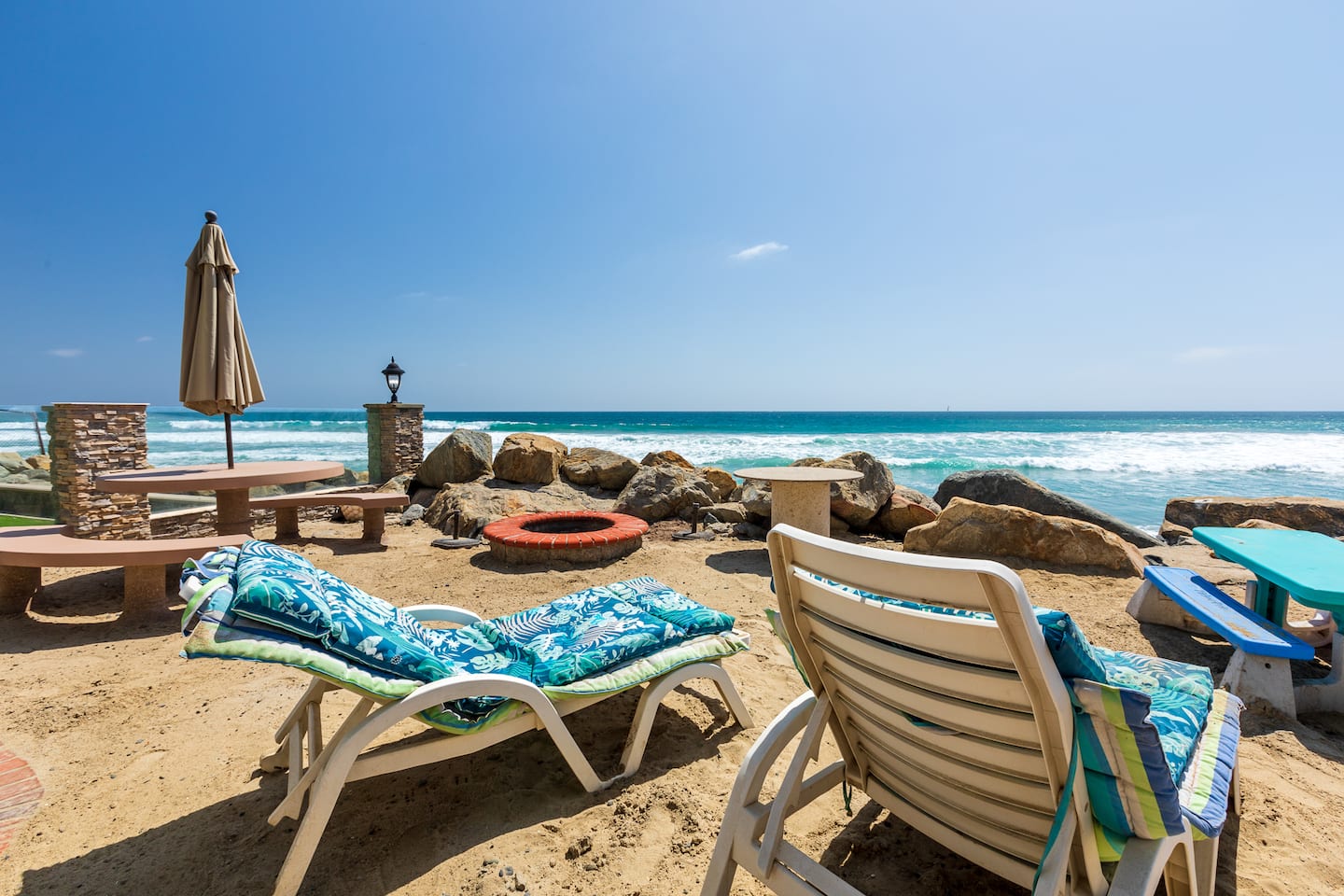 Private sand level with fire pit and lounge chairs